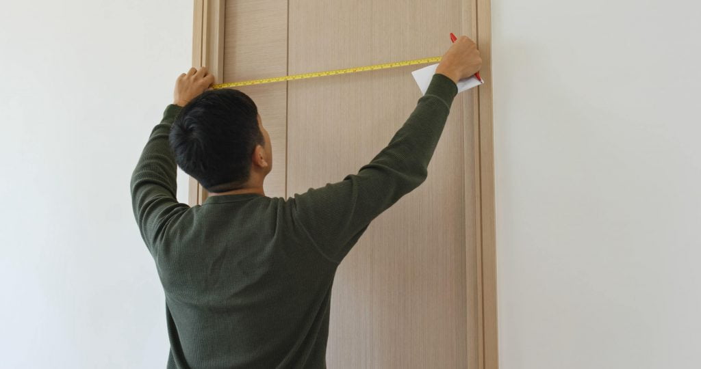 man measure door size