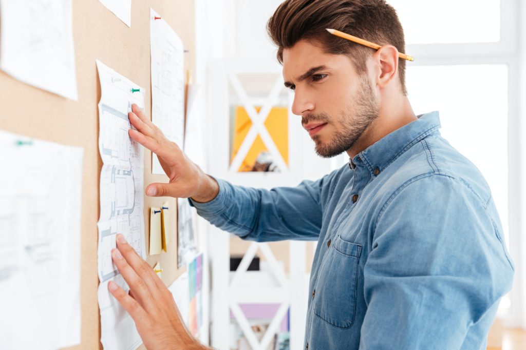 Close up portrait of businessman posting diagram at the board