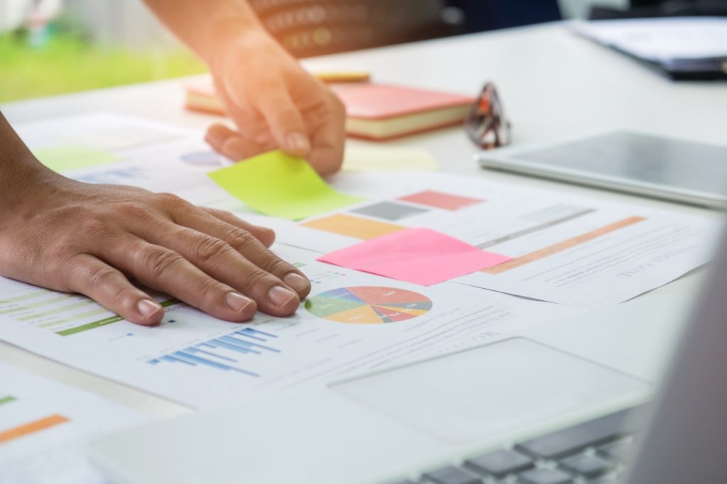 Office worker analyzing graph,other hand catches a flip chart.